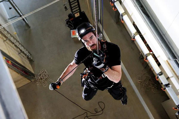 A worker suspended at height using fall arrest equipment including rope