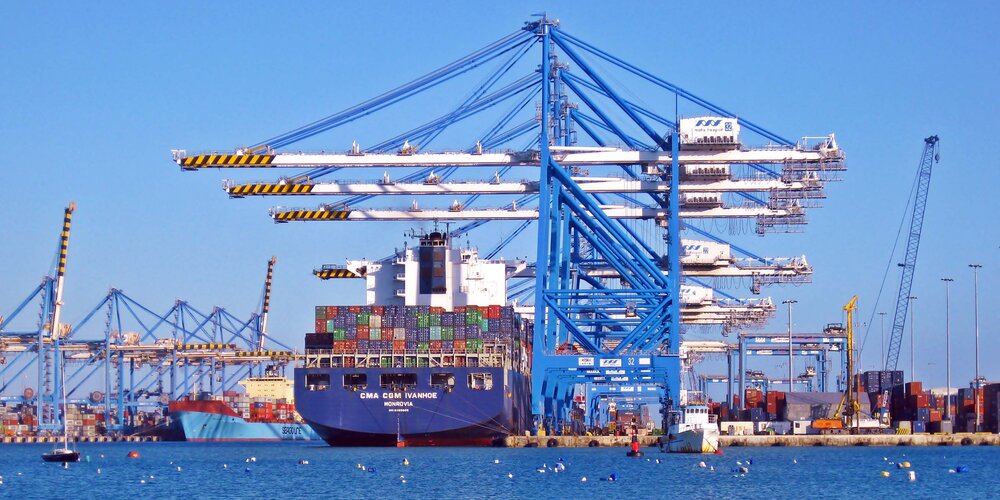 A Vessel Docked at port with containers being lifting using steel wire rope on port cranes