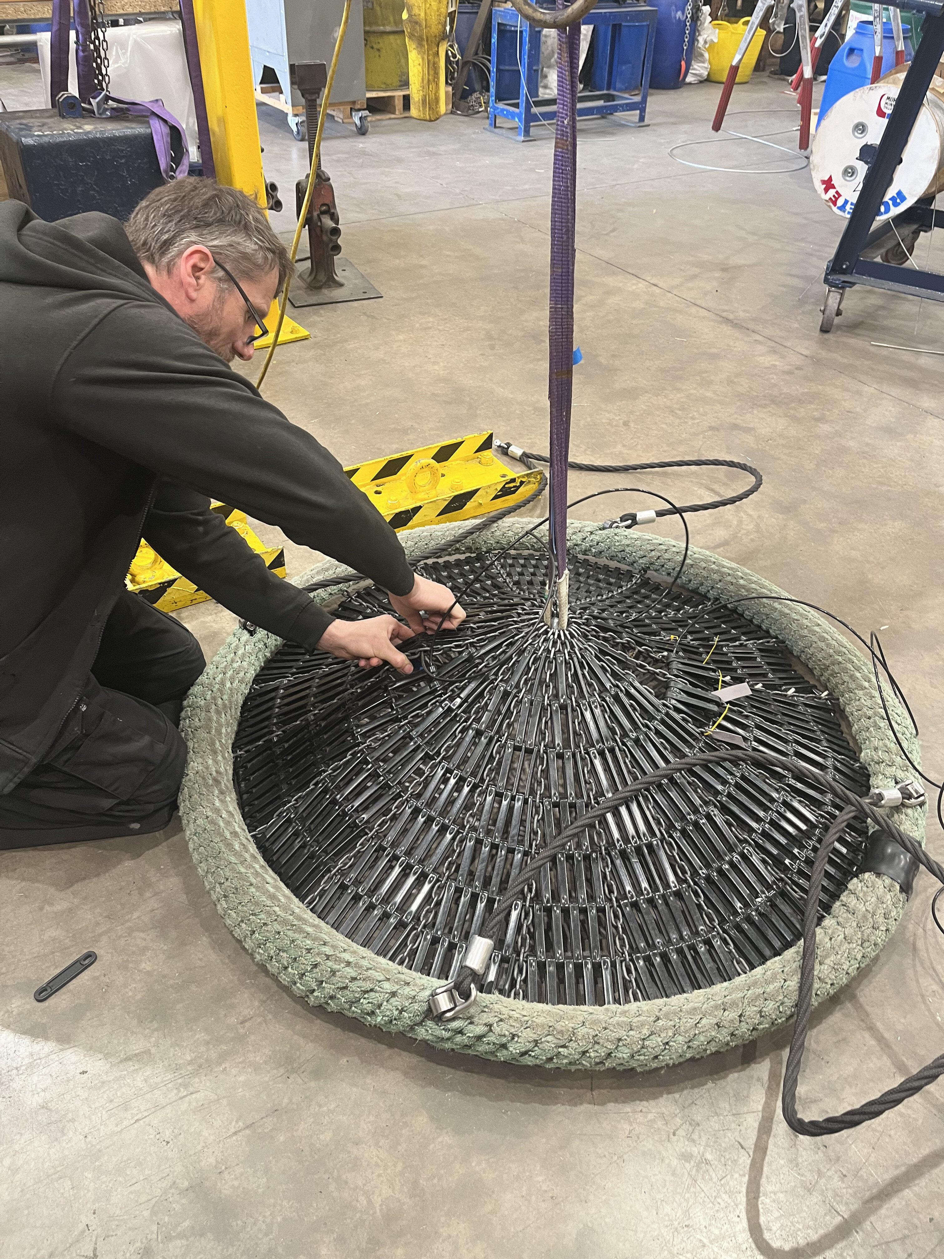 Repaired playground rope basket swing with replacement support ropes