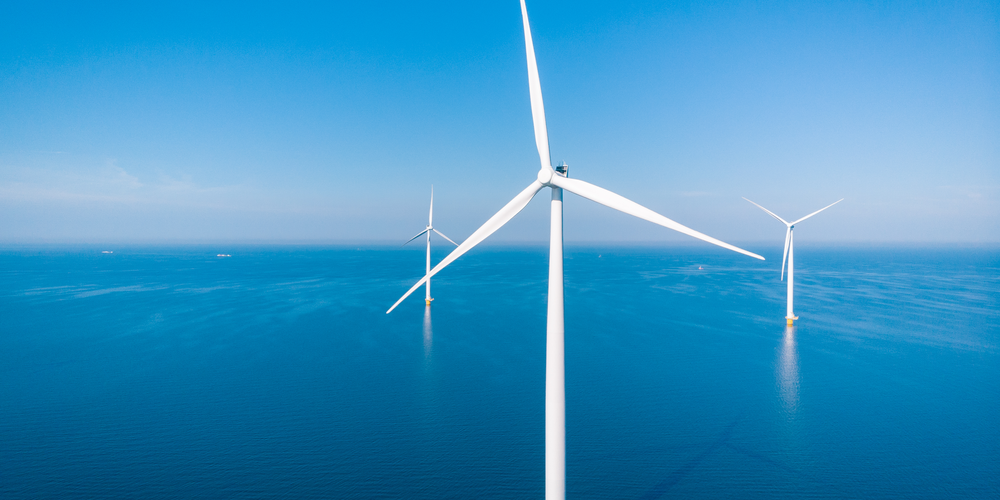 An image of wind turbines in the middle of the sea, offshore, ocean.