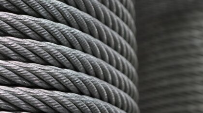 A close up of steel wire rope as it is wrapped around a reel in a circular fashion